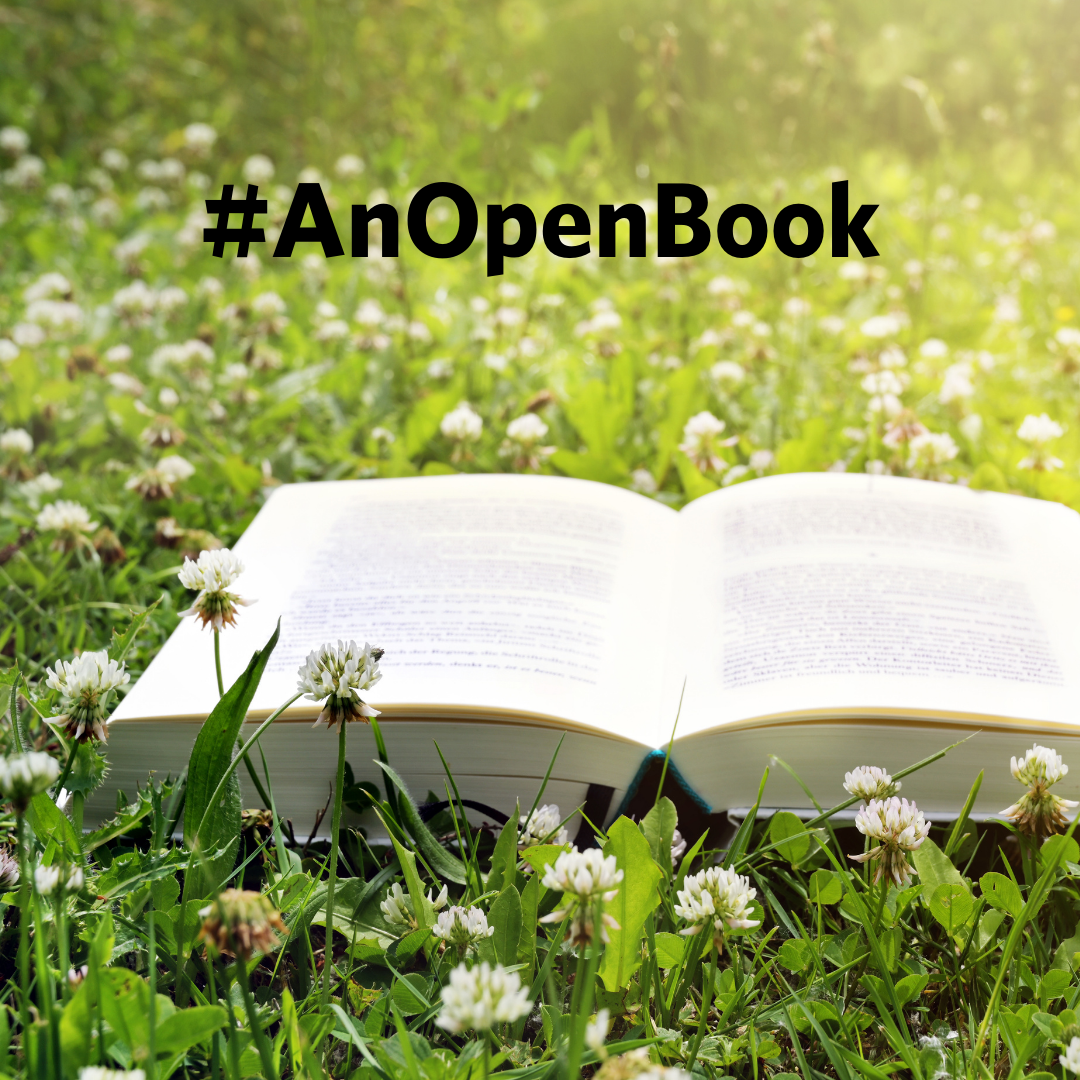 open book in field of clover with #anopenbook hashtag