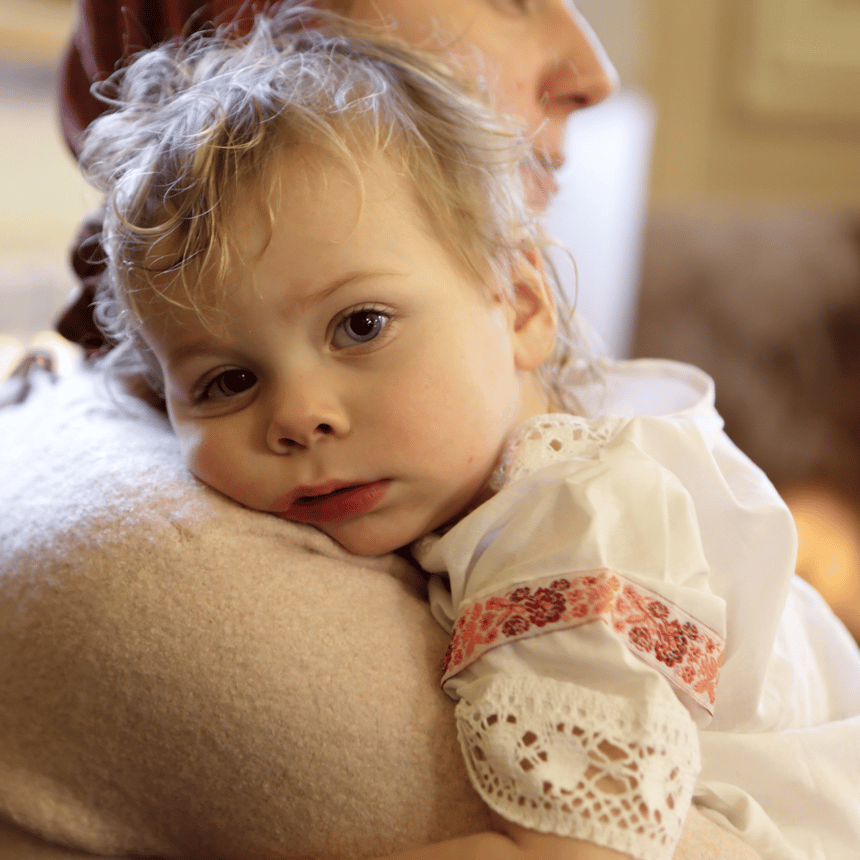 mom holding tired toddler in church