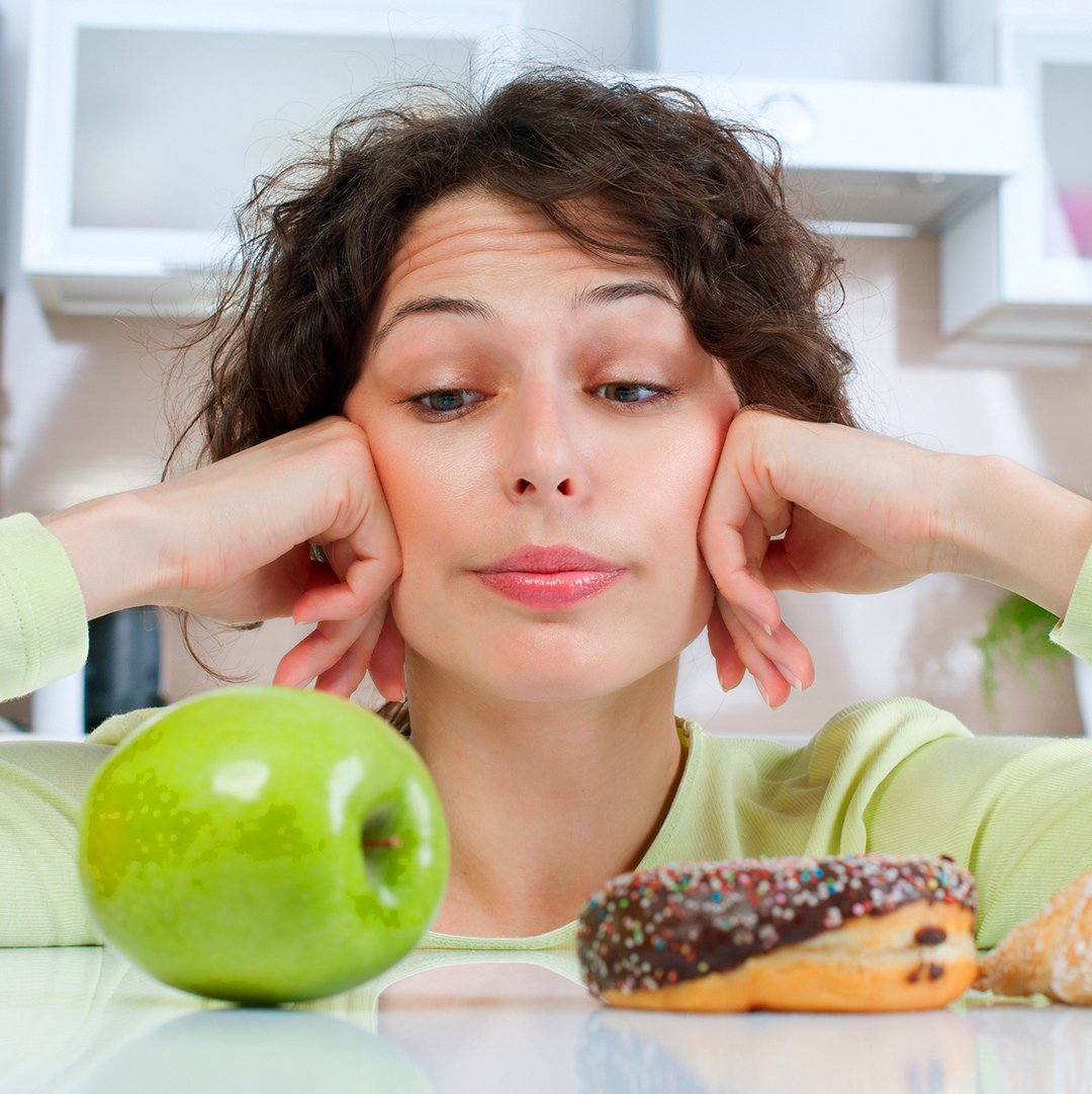 woman choosing between apple and donut