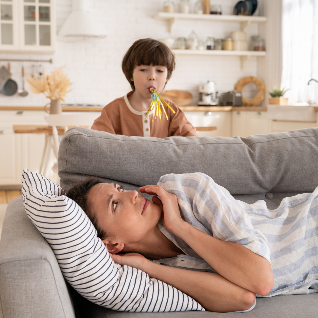 mom trying to rest with child using a noisemaker over her head