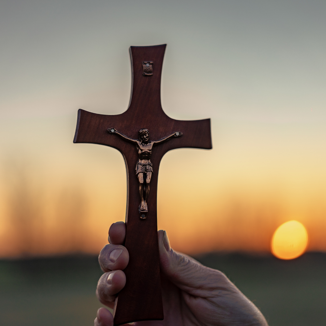 wooden crucifix with blurred sunset in background