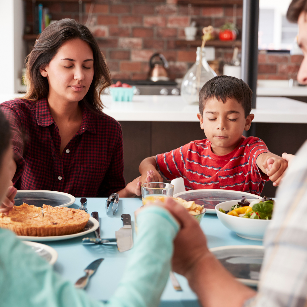 family praying at the dinner table