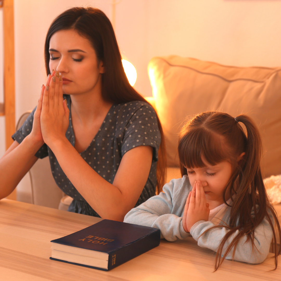 mom and little girl praying