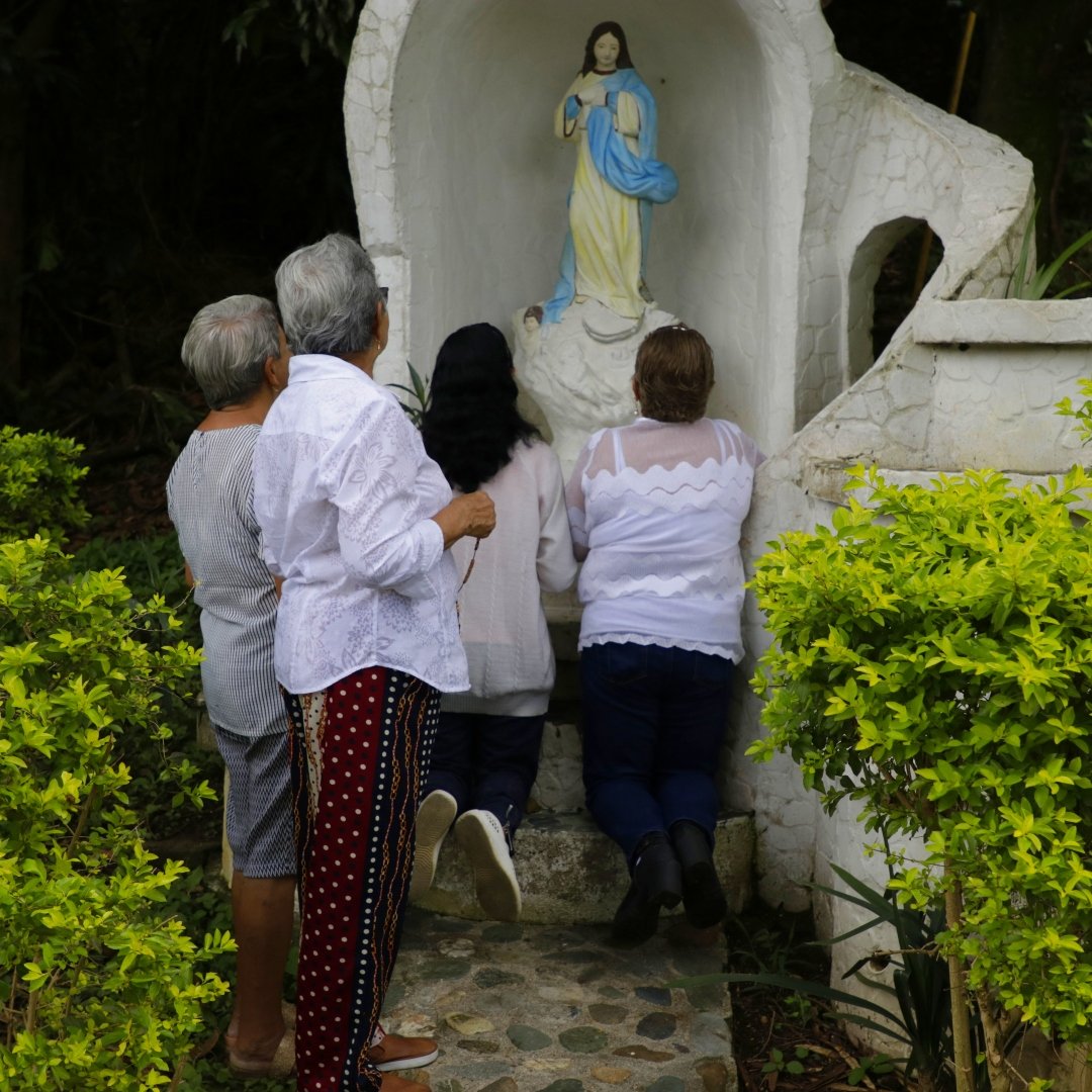 women in colombia praying at a grotto