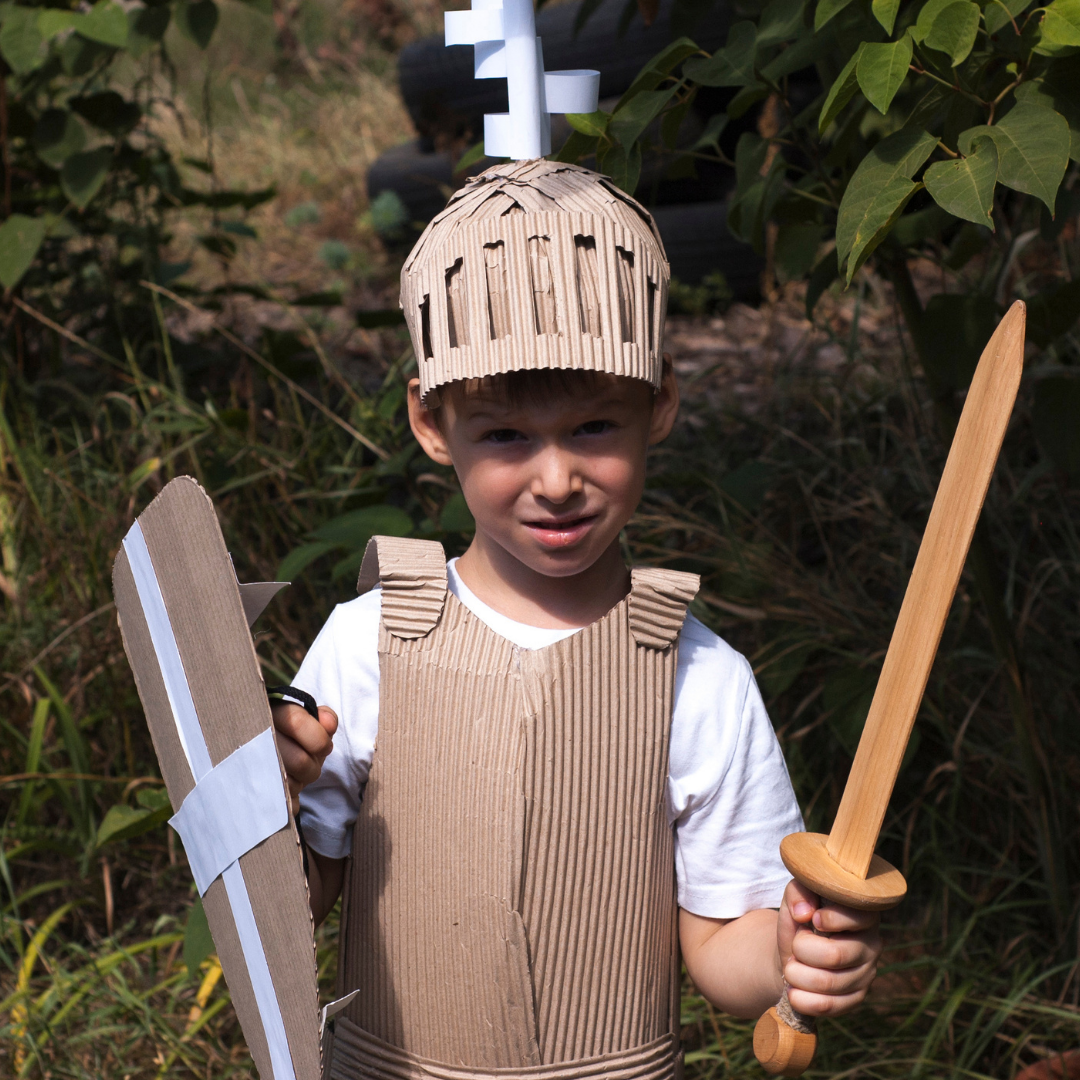 little boy in knight costume with sword, helmet, and shield