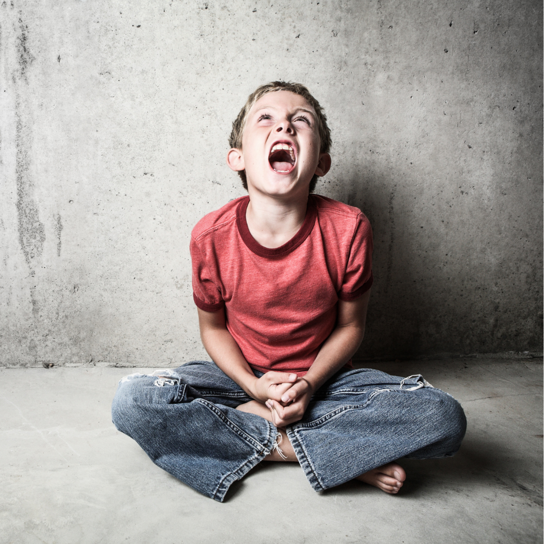 angry child sitting on the ground and yelling