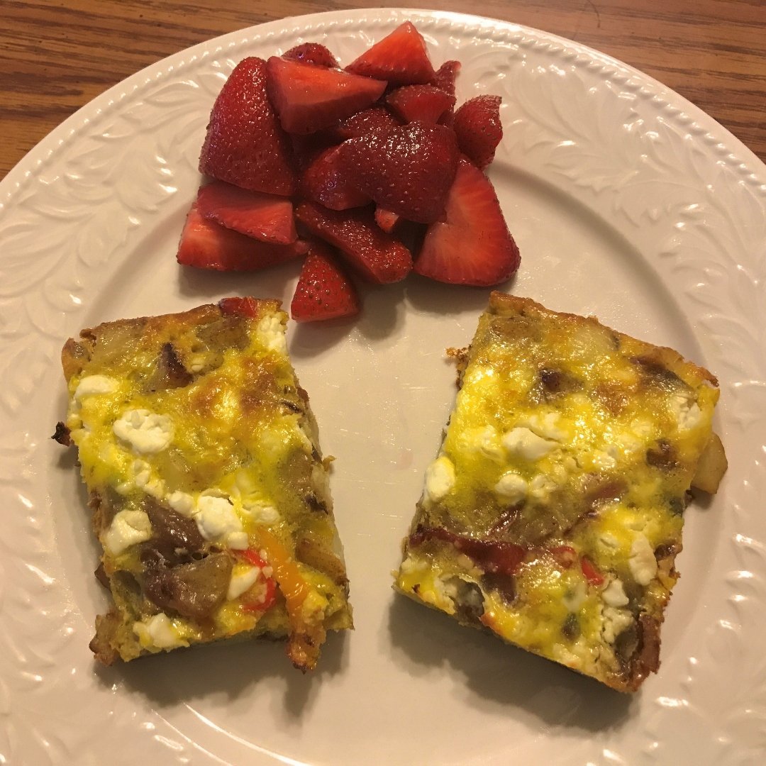 potato frittata on a plate with strawberries on the side