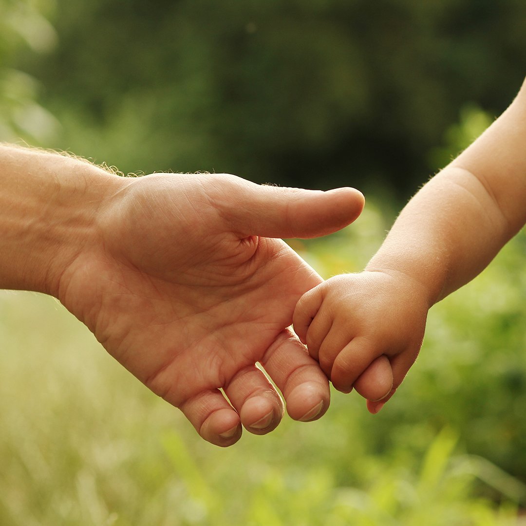 little child holding adult's finger