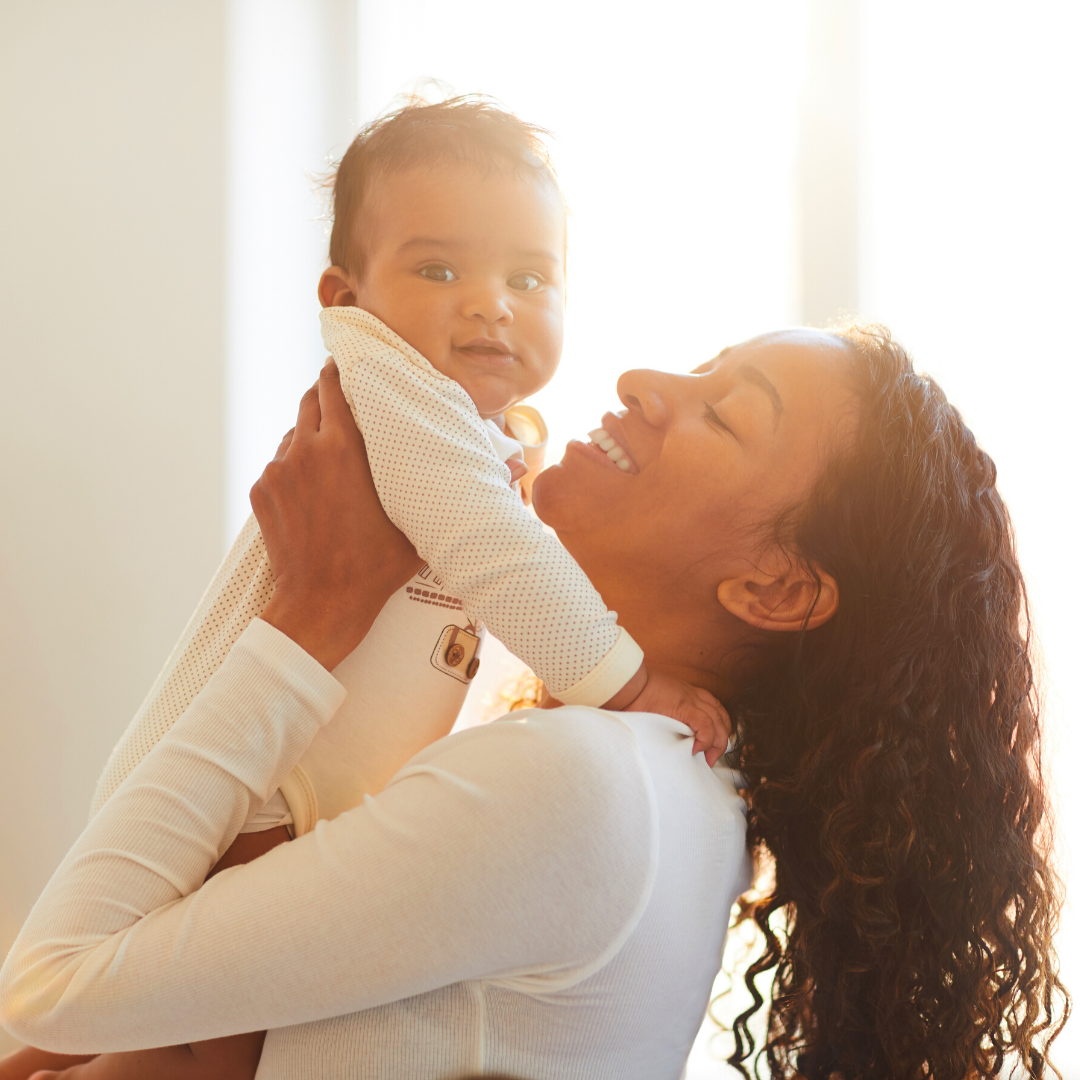 mother holding baby and smiling