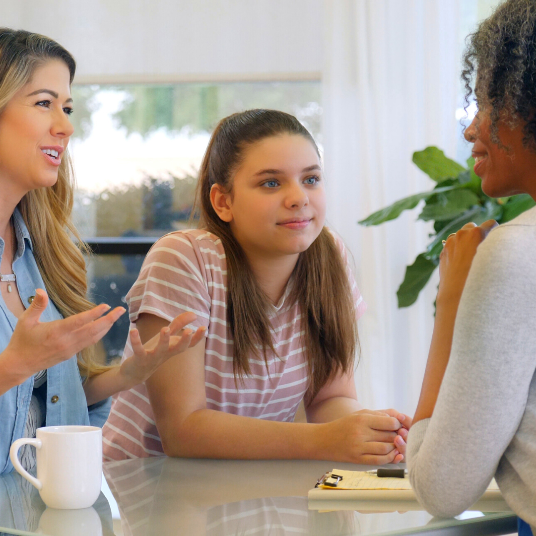 2 young girls talking with a mom