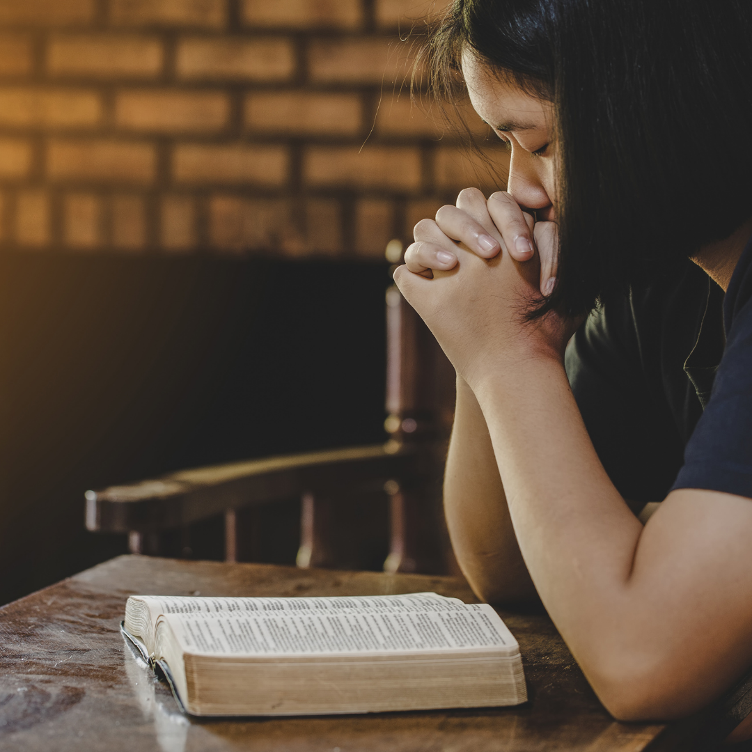woman praying with a Bible