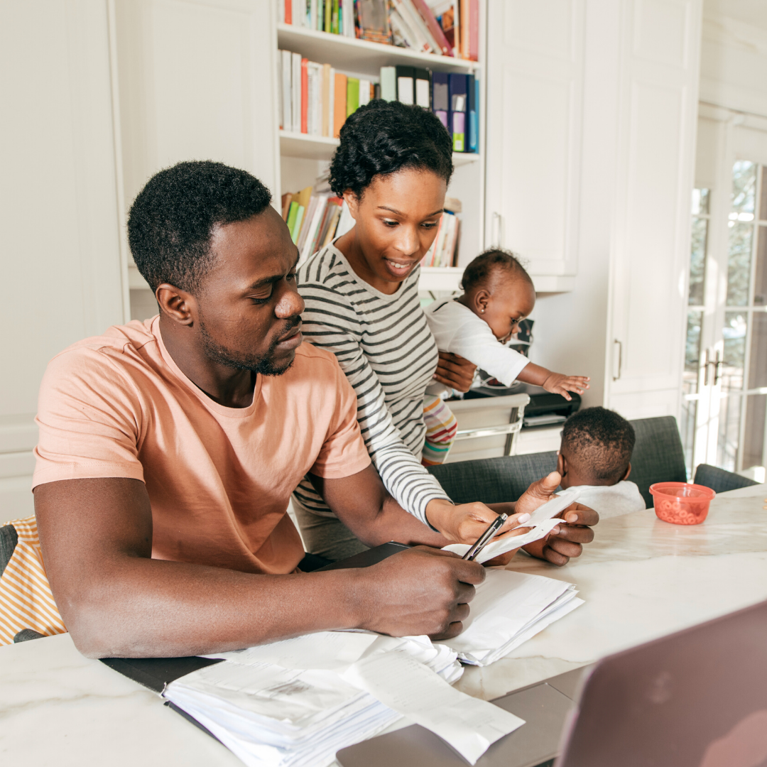 mom holding baby, helping with bills, watching child