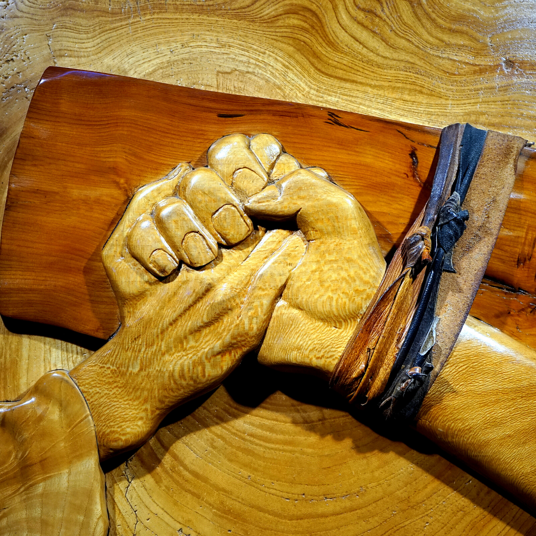 sculpture of crucifix with someone holding Jesus' hand