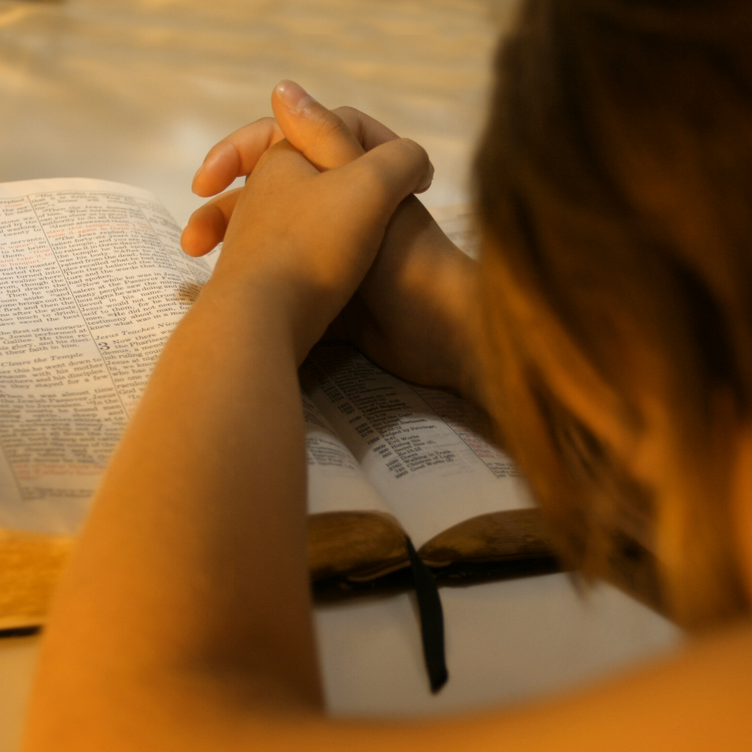 woman praying and reading a Bible