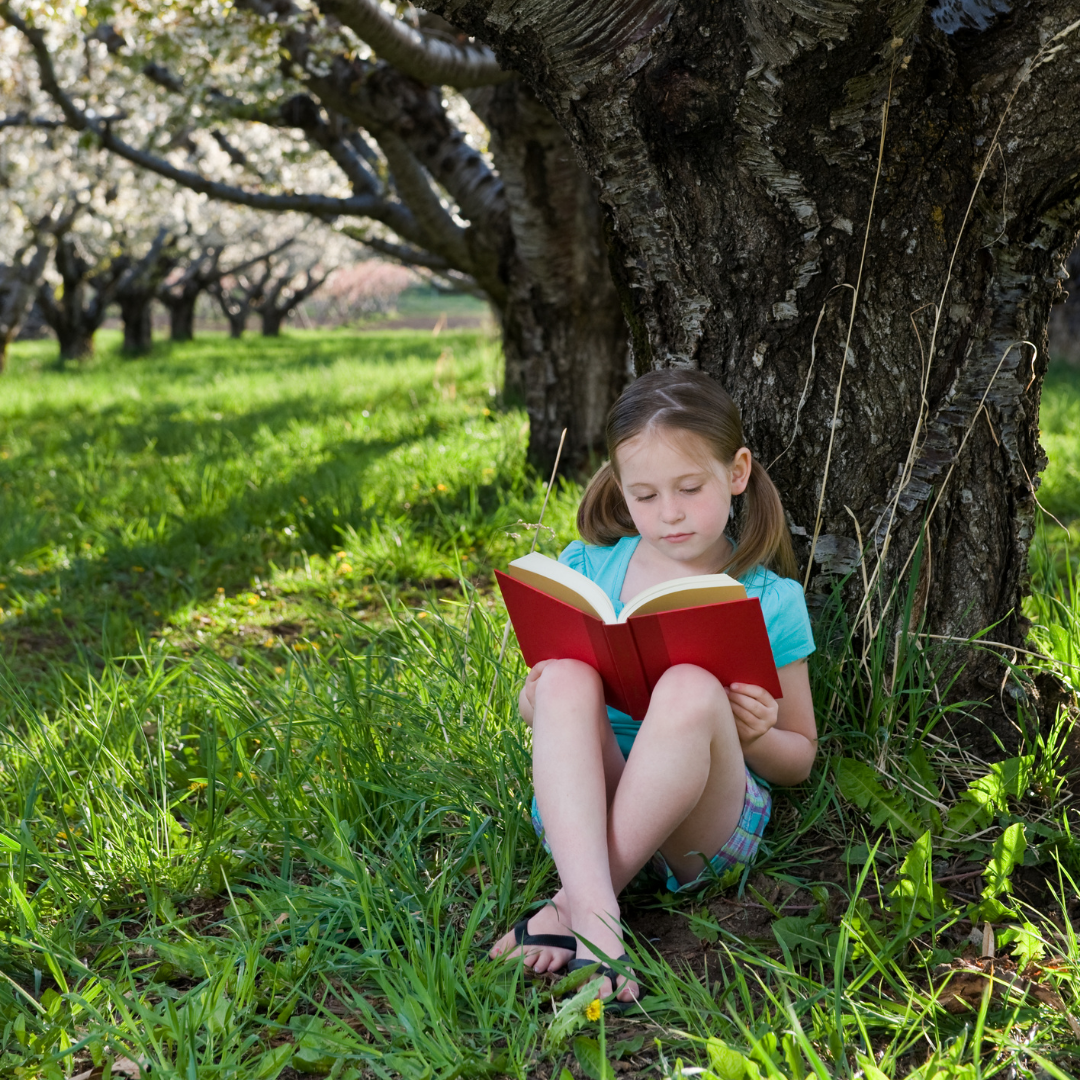 girl reading under a tree