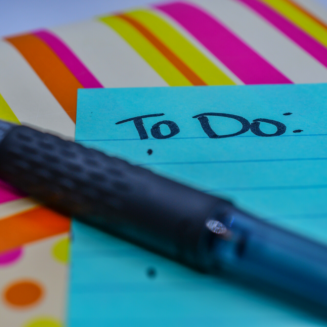to-do list sticky note on top of a planner with a pen