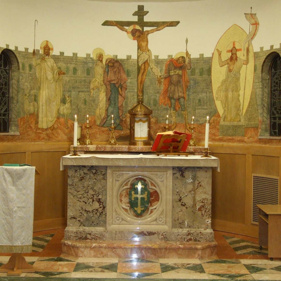 altar in church with mural of crucifixion in background