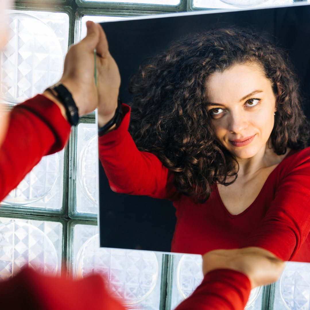 woman holding up a mirror