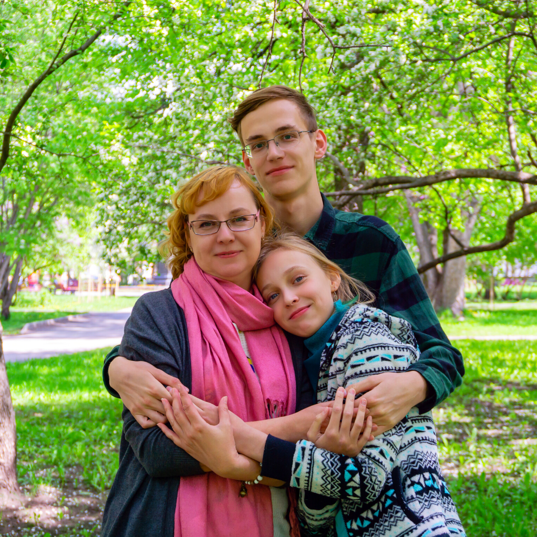 2 teenagers hugging their mom