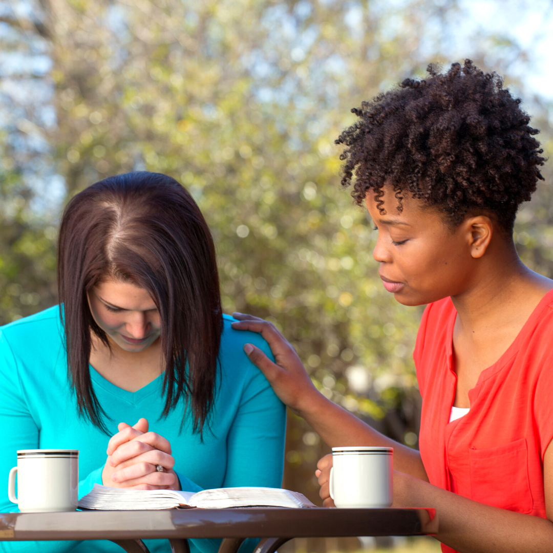 2 women praying together