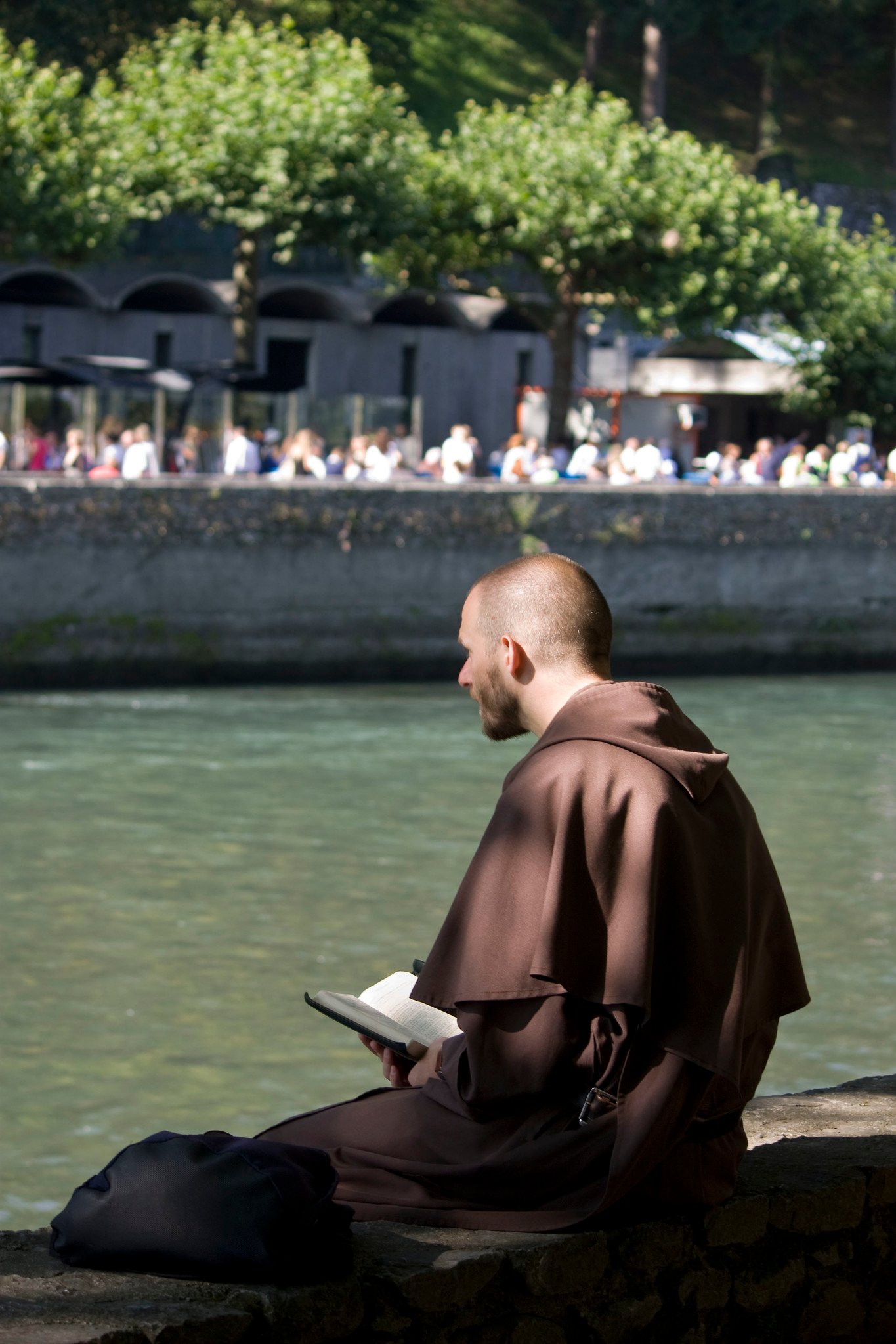 friar praying along a riverbank