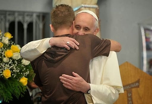 Pope Francis hugs man during visit to rehab hospital