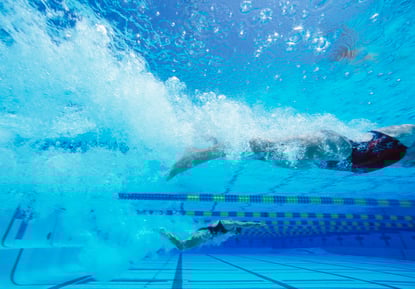 Young Caucasian female swimmers swimming in pool
