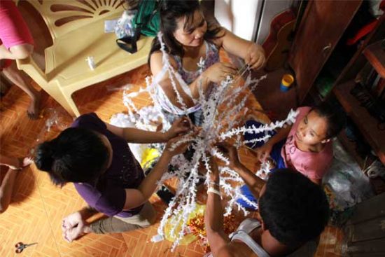 Parents of children sponsored in the Philippines turn tree branches into a crepe paper Christmas tree. Photo copyright 2016 Unbound. All rights reserved.