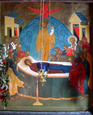 An icon of the Dormition. Mary's body is surrounded by the apostles, while Christ holds her soul, shrouded in white.