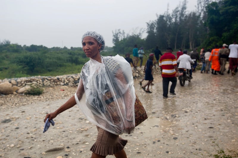 A woman protects herself from the rain with a piece of plastic prior the arrival of Hurricane Matthew, in Tabarre, Haiti, Monday, Oct. 3, 2016. AP Photo/Dieu Nalio Chery, used by Catholic Relief Services with permission