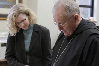 Producer Carol Ann Vaughn Cross and Abbot Cletus Meagher of Saint Bernard Abbey review archival materials 