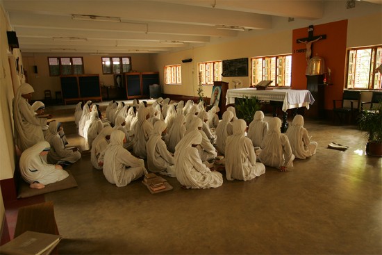 The Missionaries of Charity pray in their same chapel in 2006. Behind them, a statue of Mother Teresa sits in prayer with her sisters. Photo by Karl Grobl for CRS