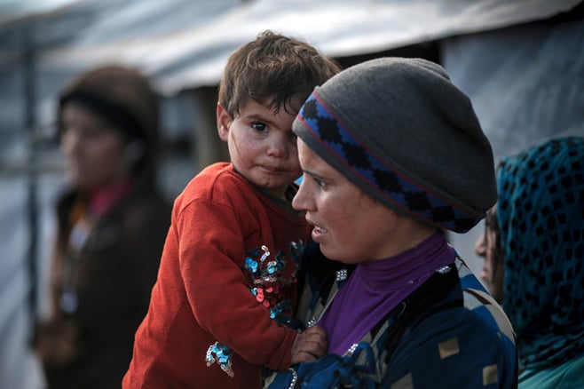 Abir holds her daughter Nejwa, 2, outside their tent. CRS supports the Good Shepherd Sisters in supplying refugees like Abir with heaters or stoves, fuel or wood, tents, blankets and gaslights to keep wolves away during winter nights. During a recent snowstorm, refugees also received extra food rations, mattresses, kitchenware and hygiene kits. Photo by Sam Tarling for CRS