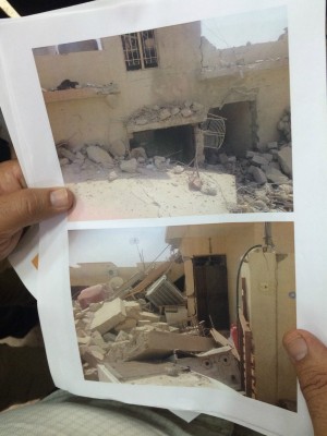 Christian refugee holds out pictures of what’s left of his home after ISIS arrived in his town