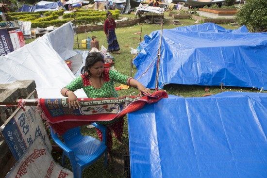 A woman sets up her tent in Lalitpur, Nepal.  Photo by Jake Lylell for CRS