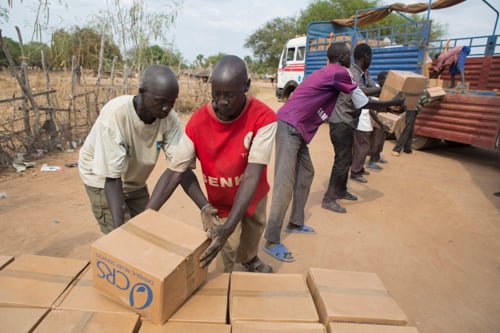 Day laborers Abraham Jok, left, and Machuei Awet load hygiene kits onto a truck for distribution at a nearby displacement camp.
