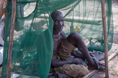 Ateny Nyieth rests under a mosquito net, one of the only items his family managed to bring when they escaped their village. Ateny, who is blind, had to be carried by family members when they fled.