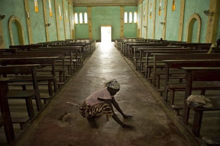 Women clean the church floor every Sunday morning before Mass at All Saints Church in Rajef. They scrub the floor by hand and rake the yard with a brush made of sticks. Photo by Karen Kasmauski for CRS.