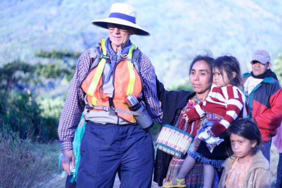 Bob greets a mother and her children while taking a break from walking. The family is one of thousands he met on his trek from Guatemala to Chile.