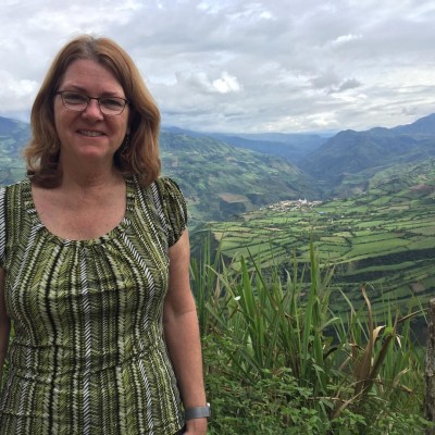 Lisa, perched on the edge of a hilltop in the Andes Mountains, Colombia. This region produces award-winning coffee.