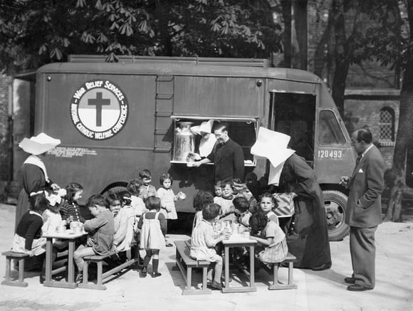 Paris, France, 1945 -  War Relief Services - National Catholic Welfare Conference (Catholic Relief Services' original name), a participating service of the National War Fund supplies hot soup and milk to the day nurseries of Paris conducted by the Sisters of Charity. Pictured is Rev. Father James H. Hoban of Cincinatti Director of the program and Dr. J. Henry Amiel of New Orleans Asst. Director during an inspection tour of the work in Paris.  Photo from the CRS archives