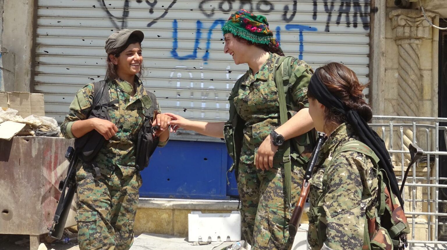 A group of fighters, part of an all-female Kurdish militia, share a laugh. Photo courtesy of: The Daughters of Kobani