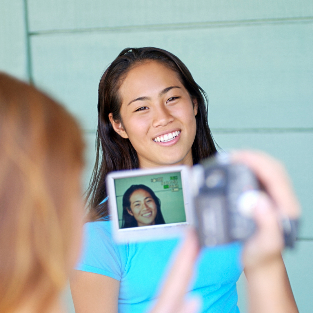 girl interviewing teenager with video camera