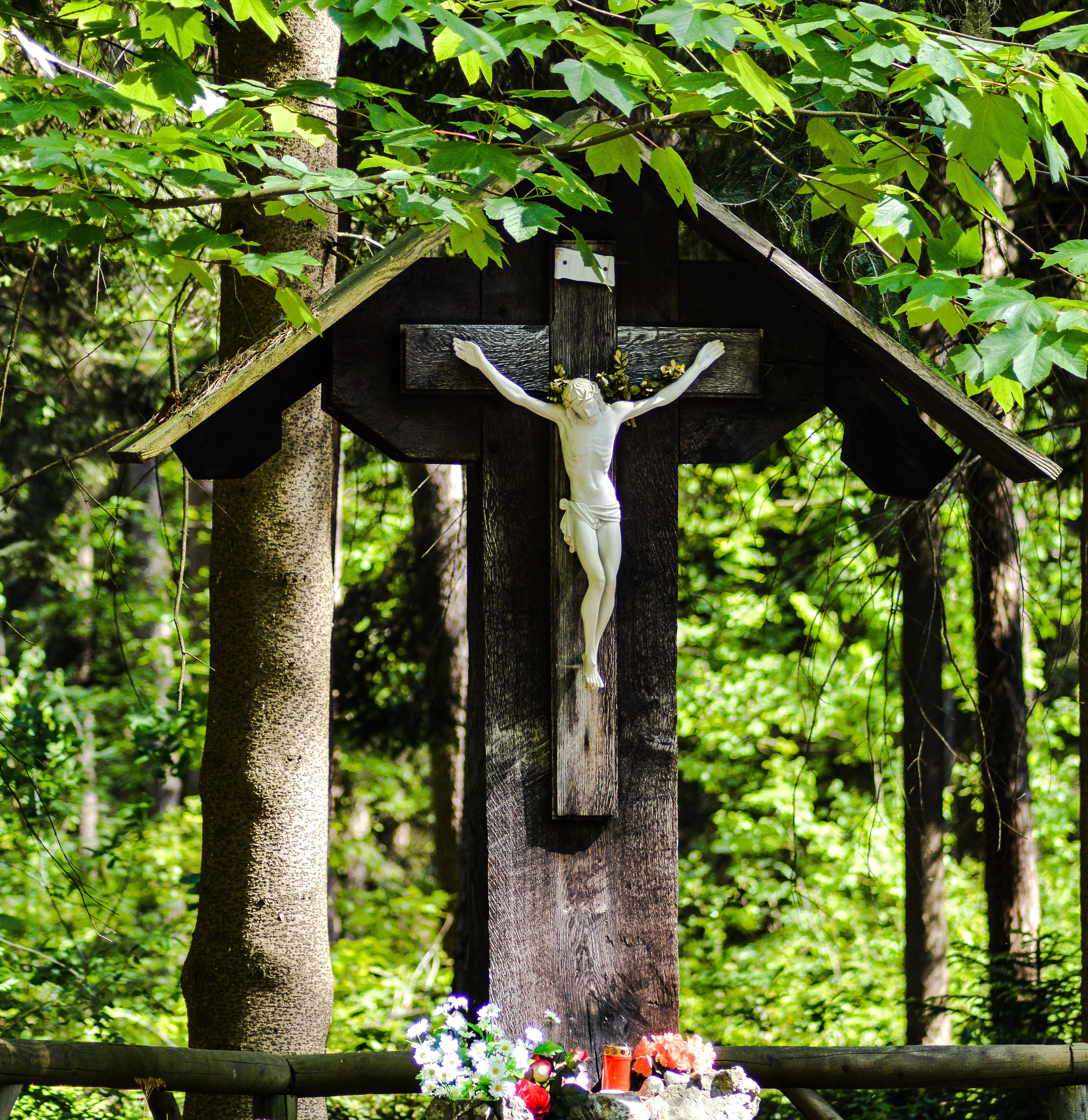 cross with flowers and candles at the foot